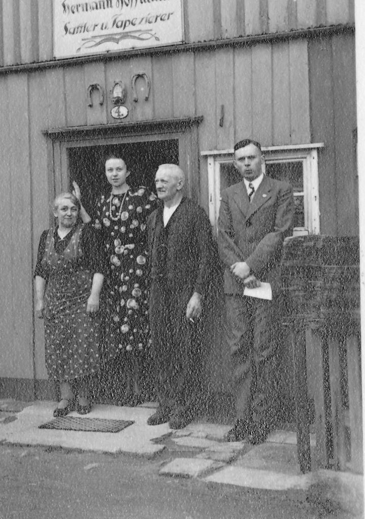 Vier Personen posieren vor dem Eingang einer Sattlerei, darunter Hilde und Roland Nordhoff, die beide in die Kamera blicken. 