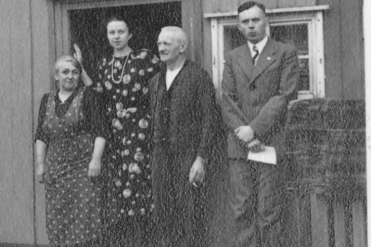 Vier Personen posieren vor dem Eingang einer Sattlerei, darunter Hilde und Roland Nordhoff, die beide in die Kamera blicken. 